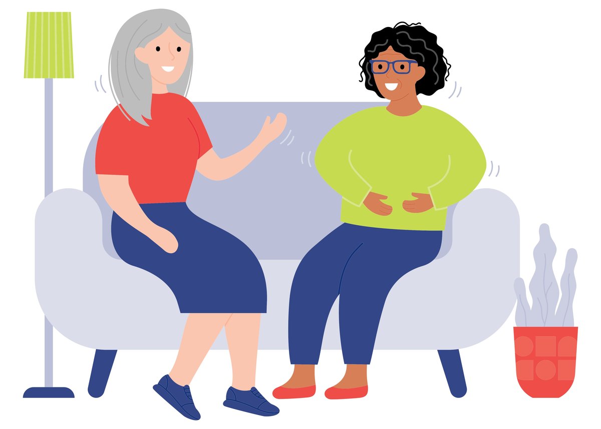 Two women talking while sitting on a couch